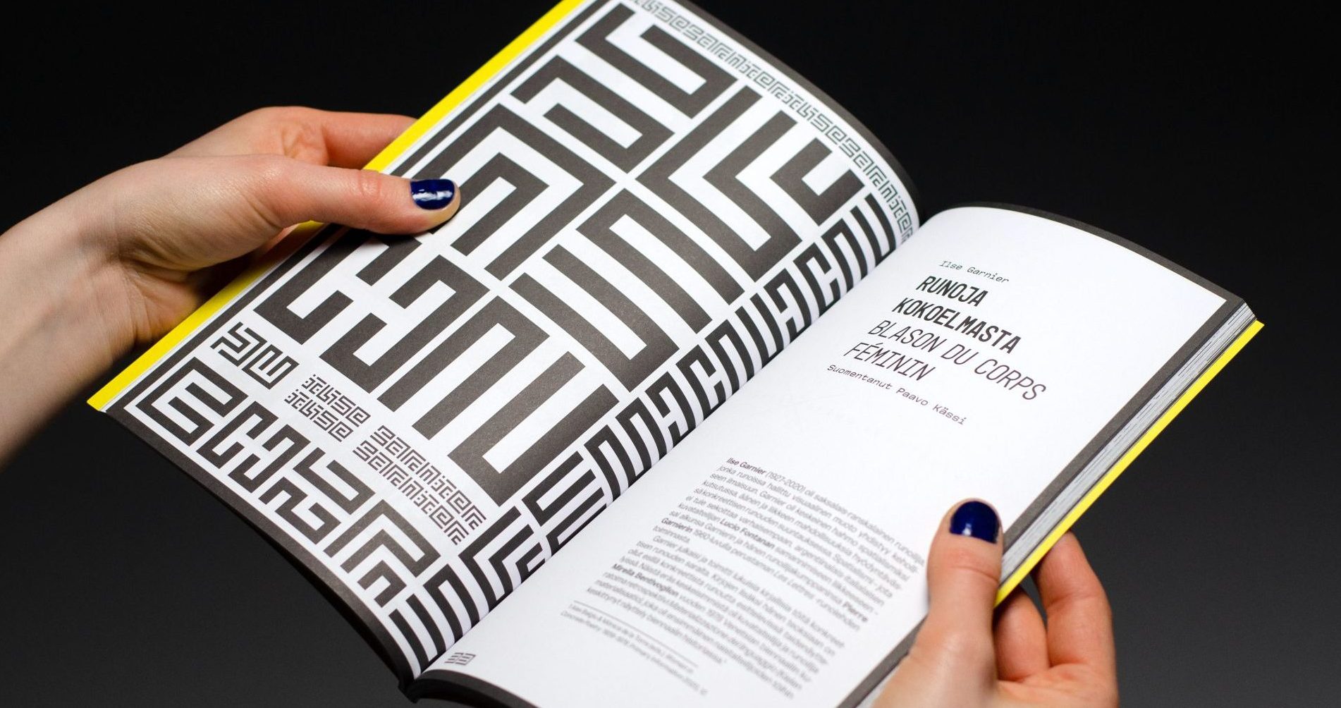 Kädet pitelemässä mustavalkoista lehteä.