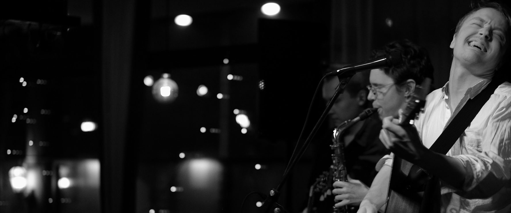 Mustavalkoinen kuva rockyhtyeestä keikalla.