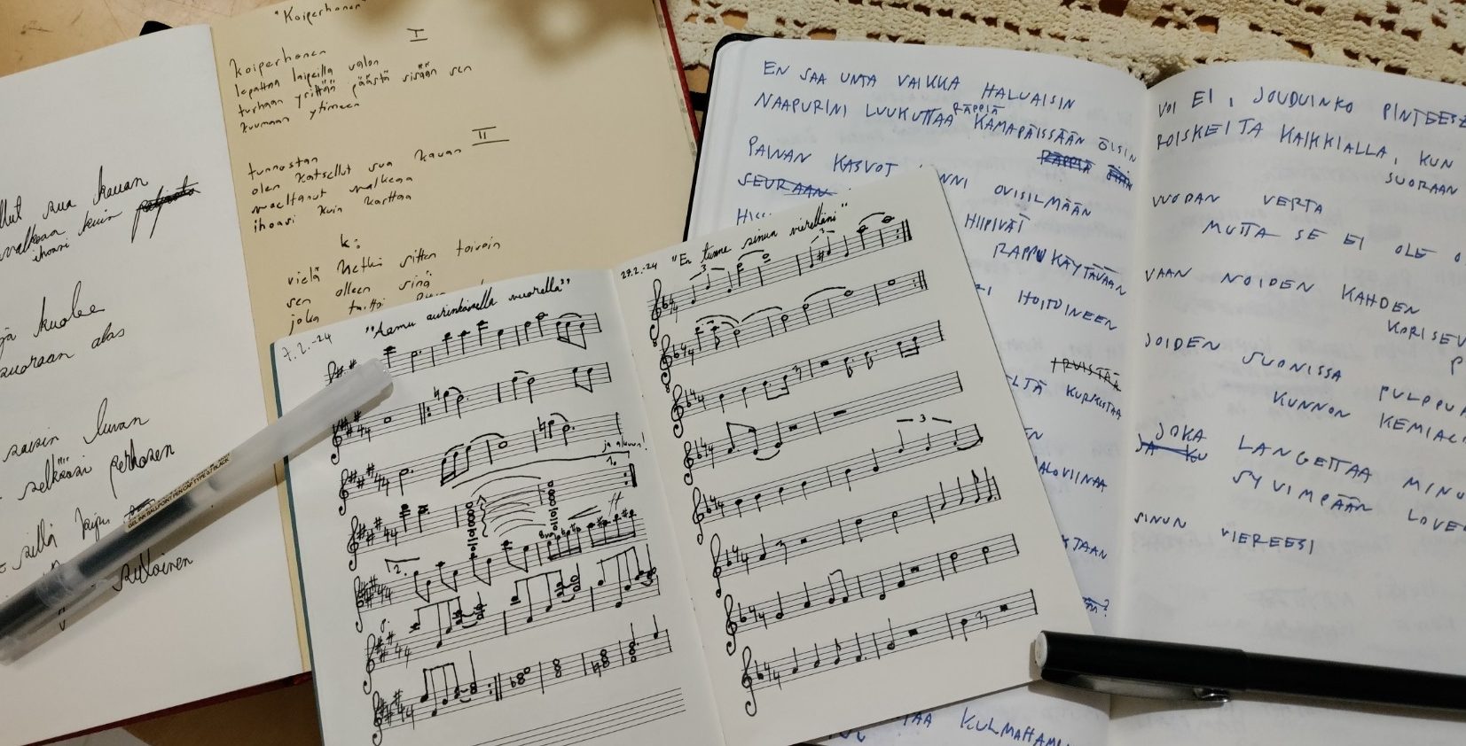 Käsin kirjoitettuja vihkoja ja nuotteja.